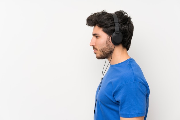 Foto hombre guapo escuchando música con auriculares