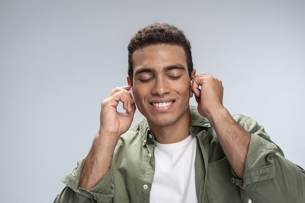 Hombre guapo escuchando música con los ojos cerrados