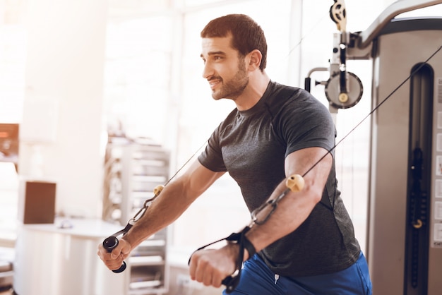 Hombre guapo está entrenando en el gimnasio.