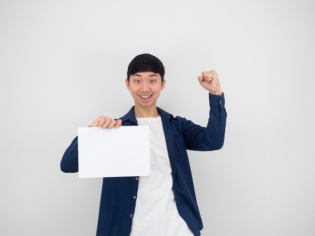 Hombre guapo feliz y alegre puño hacia arriba y sosteniendo papel en blanco en la mano con sonrisa mirar a cámara en blanco aislado