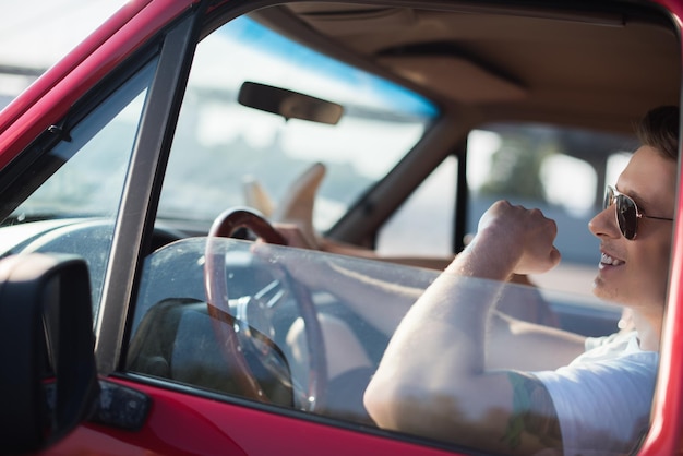 Hombre guapo feliz conduciendo coche