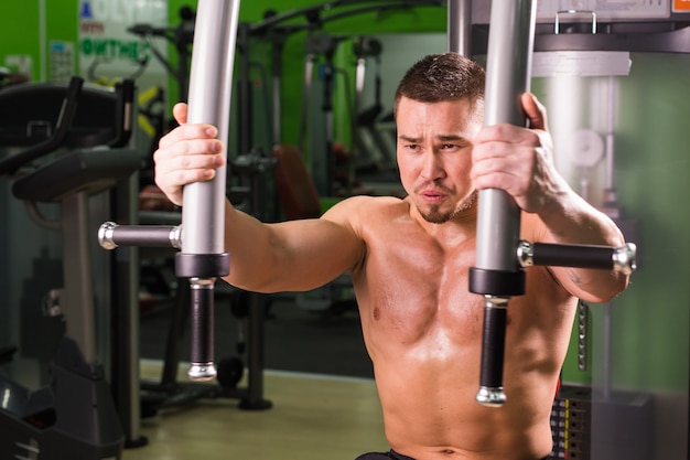 Hombre guapo fitness trabaja en el gimnasio