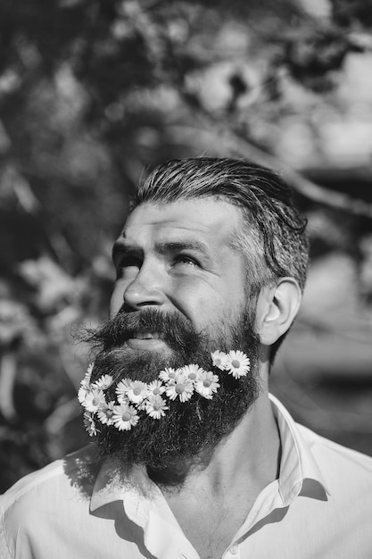 Hombre guapo con flores en la barba