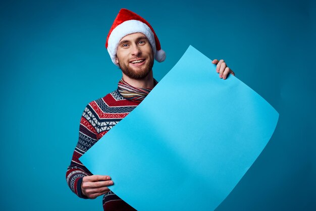 Hombre guapo en un fondo de cartel de maqueta de navidad azul aislado