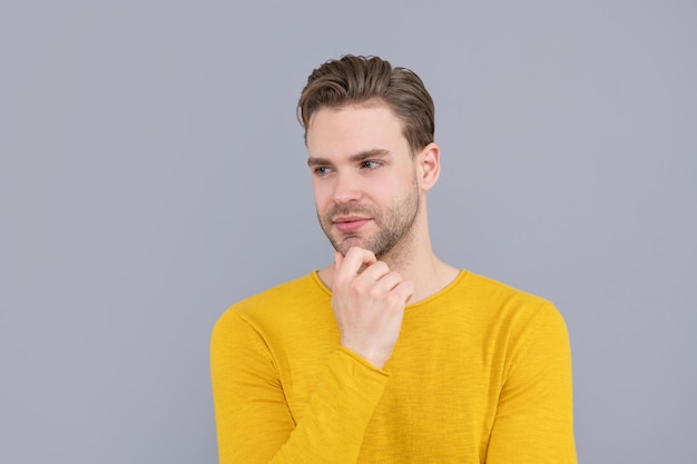 Hombre guapo con fondo gris de retrato de cara sin afeitar, serio.