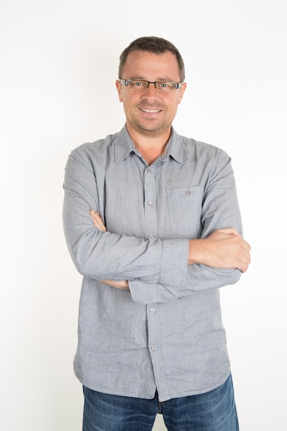 Foto hombre guapo con gafas, sin afeitar con una camisa casual azul