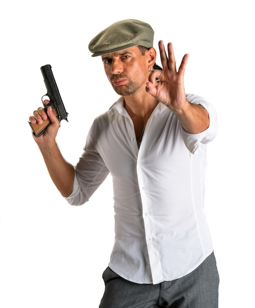 Hombre guapo con gorra con una pistola