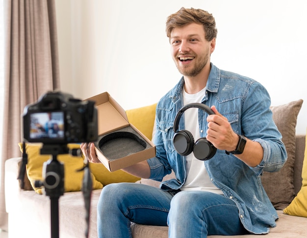 Foto hombre guapo grabando unboxing video en casa