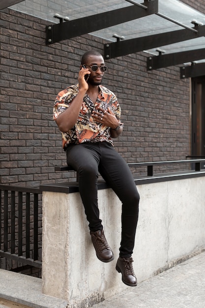 Foto hombre guapo hablando por teléfono al aire libre