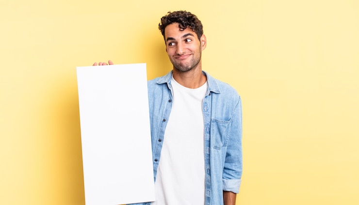 Foto hombre guapo hispano encogiéndose de hombros, sintiéndose confundido e inseguro. concepto de lienzo vacío