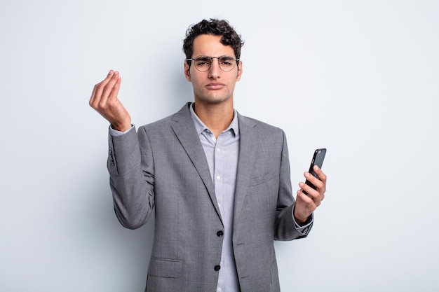 Hombre guapo hispano haciendo capice o gesto de dinero, diciéndole que pague. concepto de negocio y teléfono