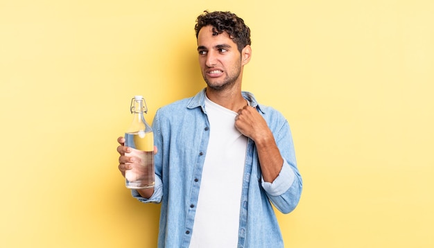 Hombre guapo hispano que se siente estresado, ansioso, cansado y frustrado. concepto de botella de agua