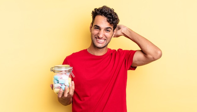 Hombre guapo hispano que se siente estresado, ansioso o asustado, con las manos en la cabeza. concepto de dulces