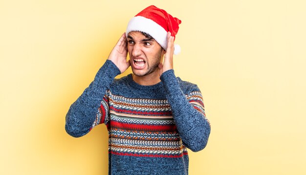 Hombre guapo hispano que se siente feliz, emocionado y sorprendido. concepto de navidad