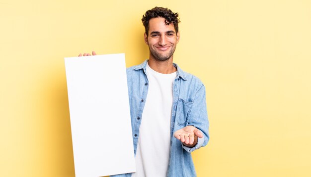 Foto hombre guapo hispano sonriendo felizmente con amigable y ofreciendo y mostrando un concepto. concepto de lienzo vacío