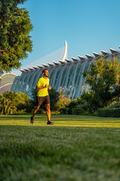 Hombre guapo hispano trotar en el jardín del parque de la ciudad de las artes y las ciencias Valencia España