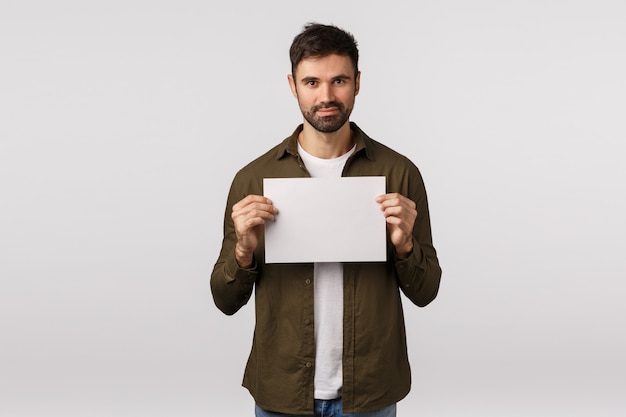 Foto hombre guapo con hoja de papel en blanco o documento