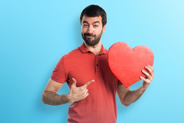 Hombre guapo con un icono del corazón en fondo colorido