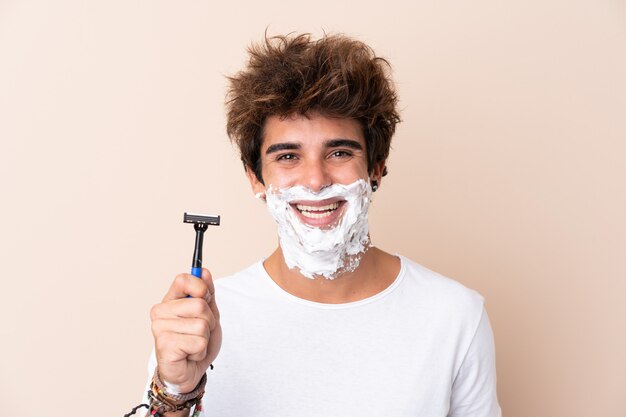 Hombre guapo joven afeitarse la barba sonriendo mucho