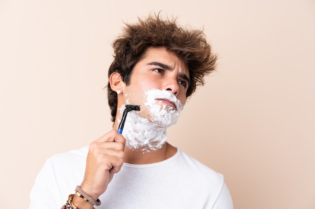 Hombre guapo joven afeitarse la barba