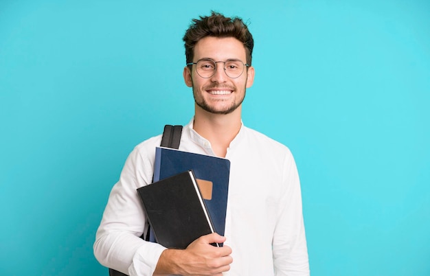 Hombre guapo joven aislado con un concepto de estudiante universitario de bolsa y libros