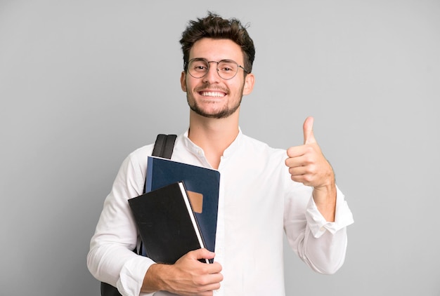 Hombre guapo joven aislado con un concepto de estudiante universitario de bolsa y libros