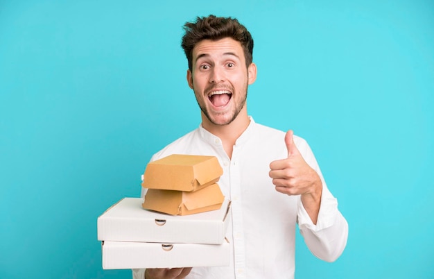 Hombre guapo joven aislado con entrega de cajas de maquetas de comida rápida y concepto de comida para llevar