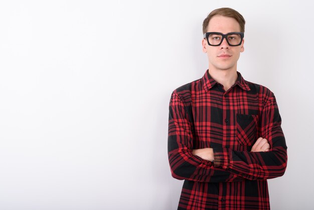 Hombre guapo joven con anteojos en la pared blanca