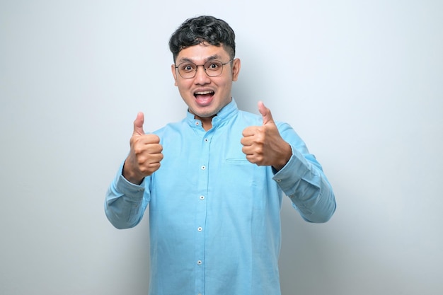 Hombre guapo joven aprobando hacer un gesto positivo con los pulgares hacia arriba sonriendo y feliz por el éxito