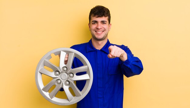 Hombre guapo joven apuntando a la cámara eligiendo su concepto de reparador de automóviles