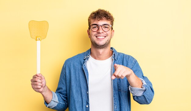 Foto hombre guapo joven apuntando a la cámara eligiéndote. concepto matamoscas