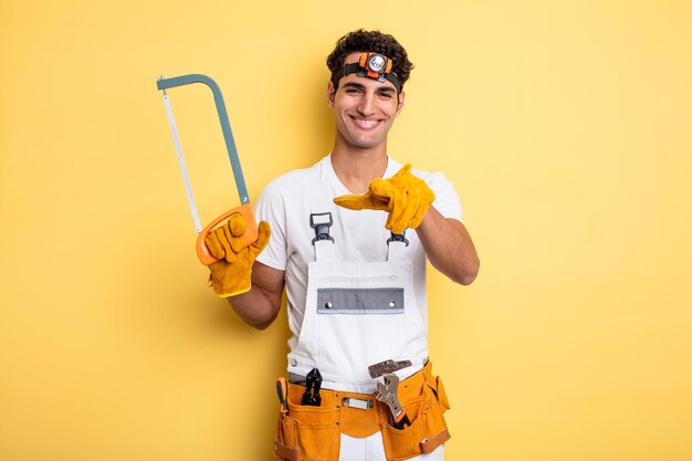 Hombre guapo joven apuntando a la cámara eligiéndote. concepto de reparación de manitas