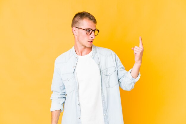 Hombre guapo joven apuntando con el dedo como si invitara a acercarse