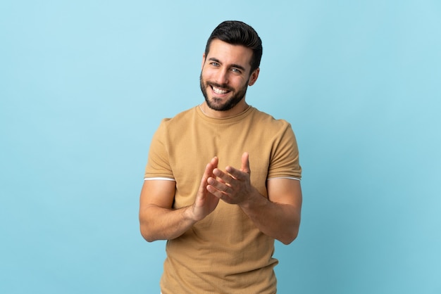 Hombre guapo joven con barba aplaudiendo después de la presentación en una conferencia