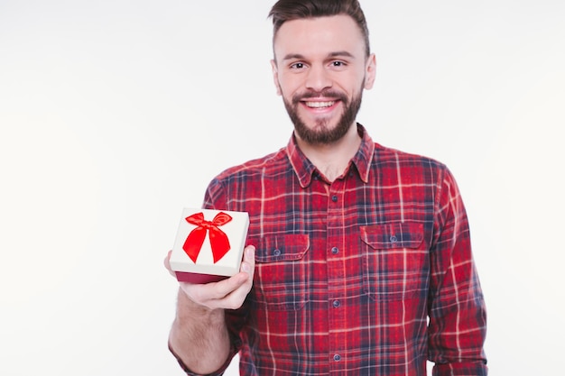 Hombre guapo joven con barba con regalo o caja de regalo en las manos Feliz cumpleaños aniversario o día de San Valentín