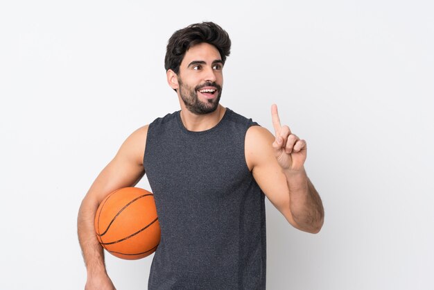 Hombre guapo joven con barba sobre pared blanca aislada jugando baloncesto y tener una idea