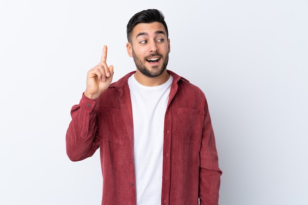 Hombre guapo joven con barba vistiendo una chaqueta de pana aislada con la intención de realizar