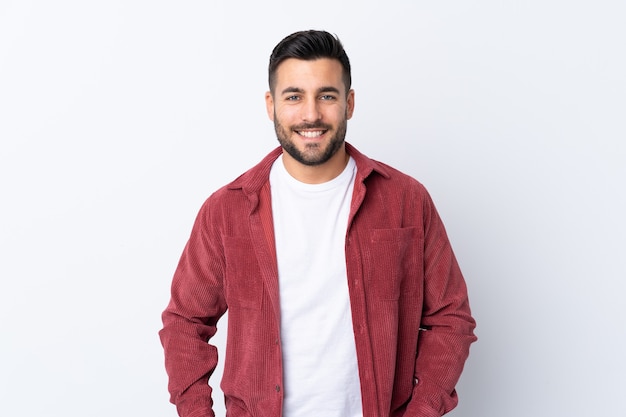 Hombre guapo joven con barba vistiendo una chaqueta de pana aislado riendo