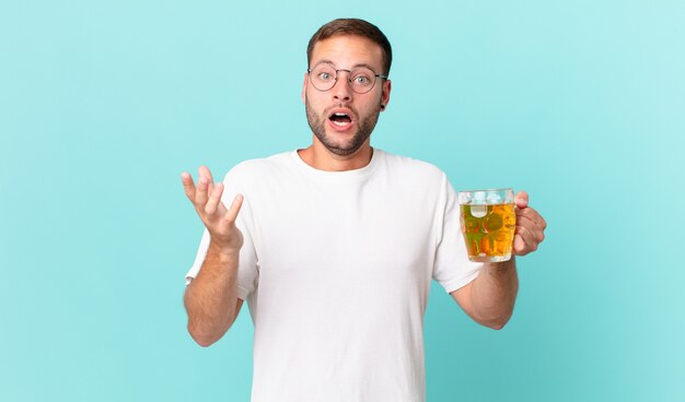 Hombre guapo joven bebiendo una pinta de cerveza