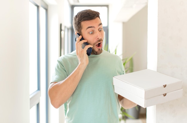 Hombre guapo joven con cajas de pizza para llevar en casa