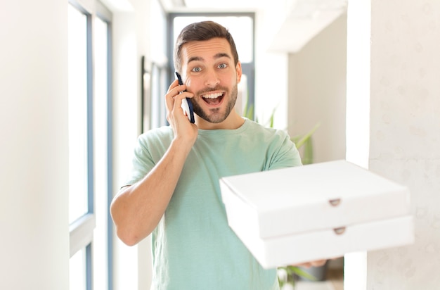 Hombre guapo joven con cajas de pizza para llevar en casa