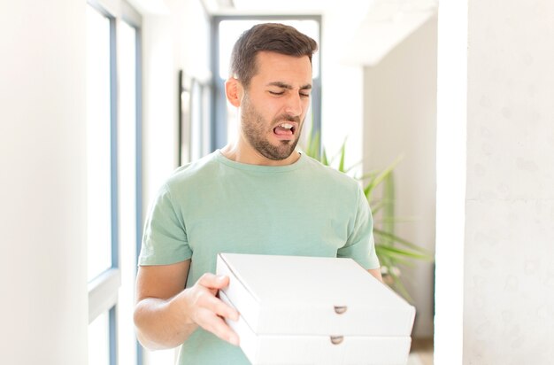 Hombre guapo joven con cajas de pizza para llevar en casa