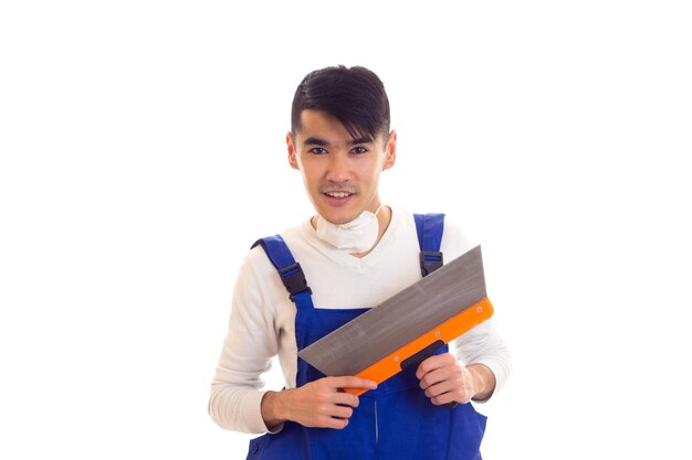 Hombre guapo joven en camisa blanca y azul en general con respirador blanco con espátula