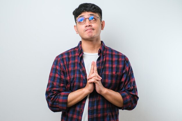 Hombre guapo joven con camisa casual pensando preocupado por una pregunta preocupada y nerviosa con la mano en la barbilla