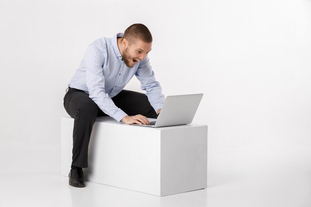 Hombre guapo joven en camisa y corbata usando laptop