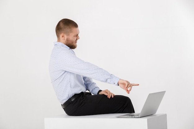 Foto hombre guapo joven en camisa y corbata usando laptop