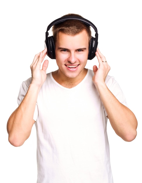 Hombre guapo joven en camiseta blanca escuchando música en los auriculares