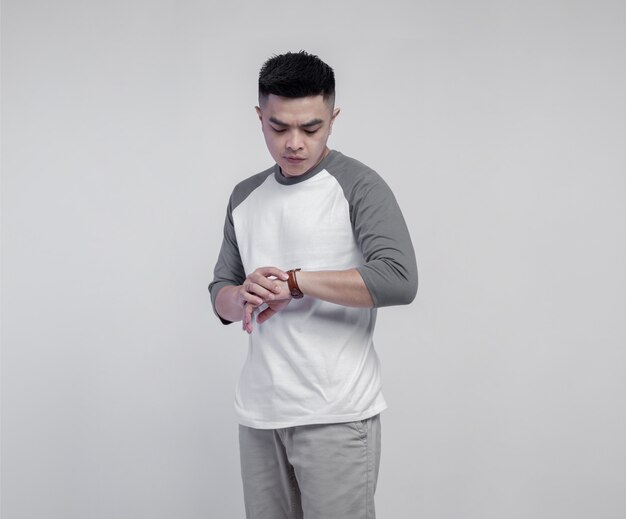 Hombre guapo joven con camiseta raglán gris blanca