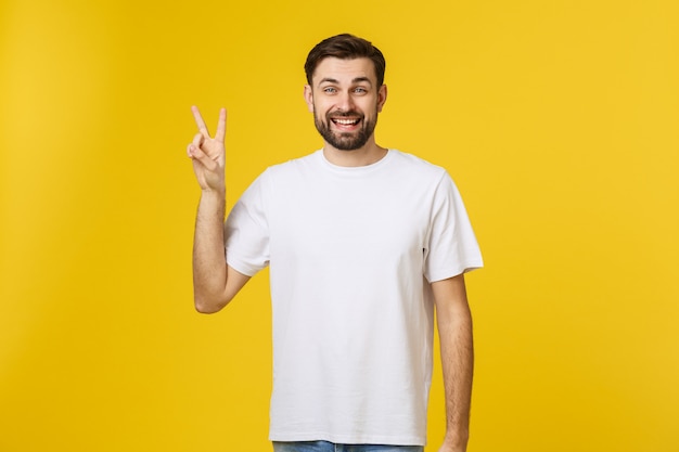 Hombre guapo joven con camiseta a rayas sobre amarillo aislado sonriendo mirando a la cámara