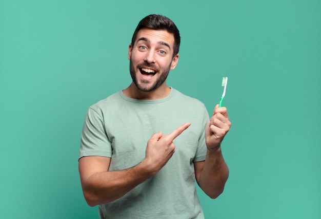 Hombre guapo joven con un cepillo de dientes.